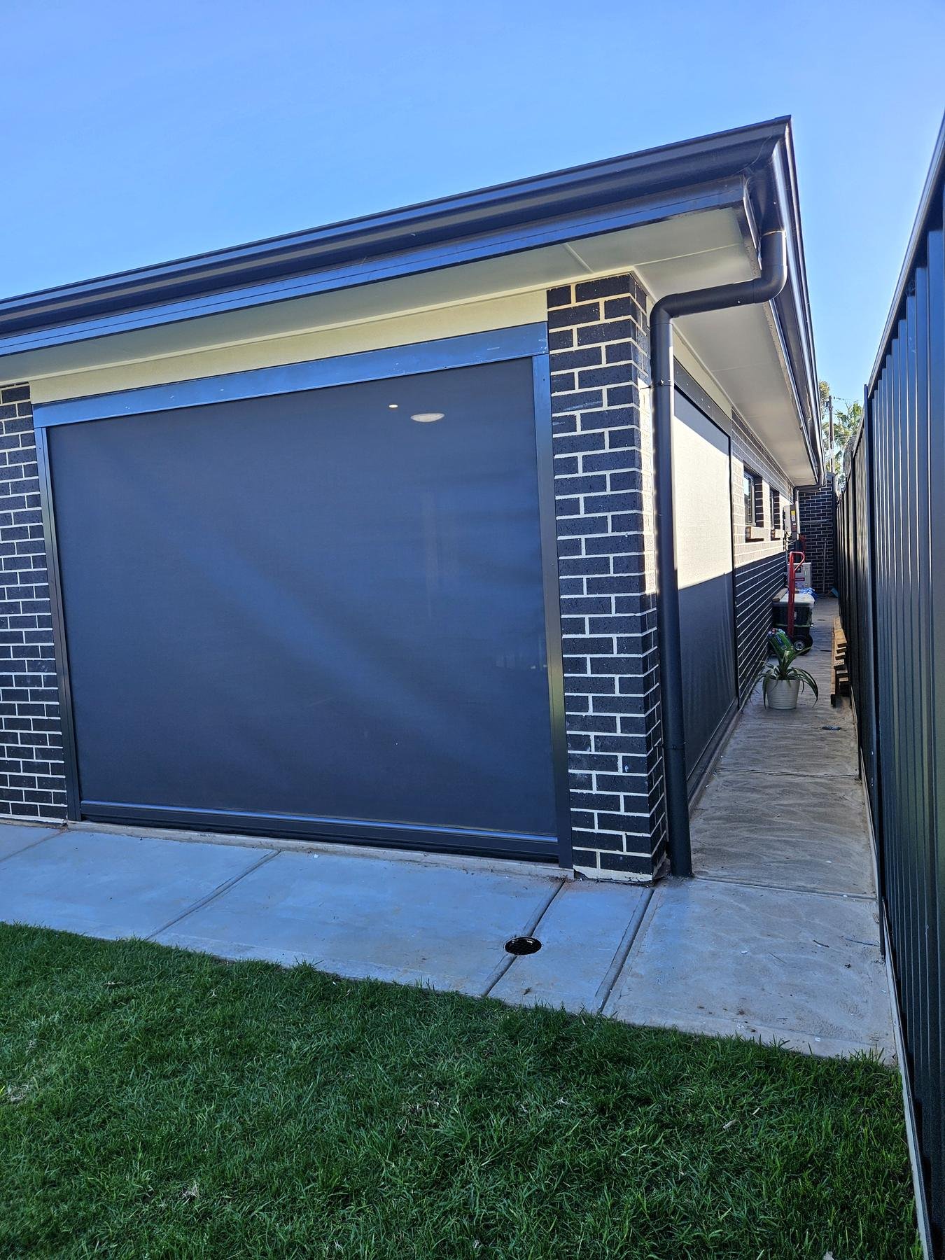 Outdoor blind lowered on a brick patio