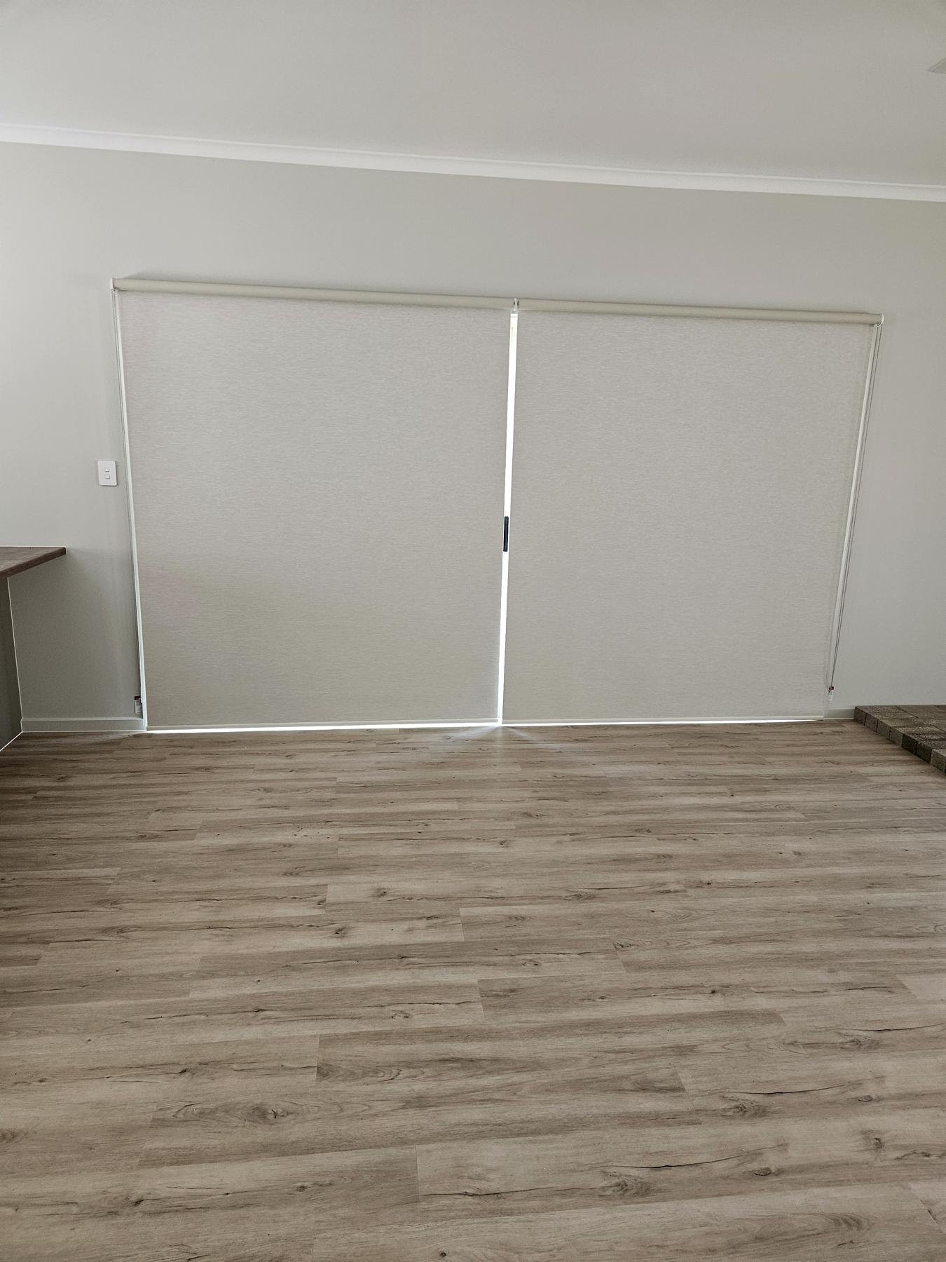 Roller blinds lowered over a sliding door