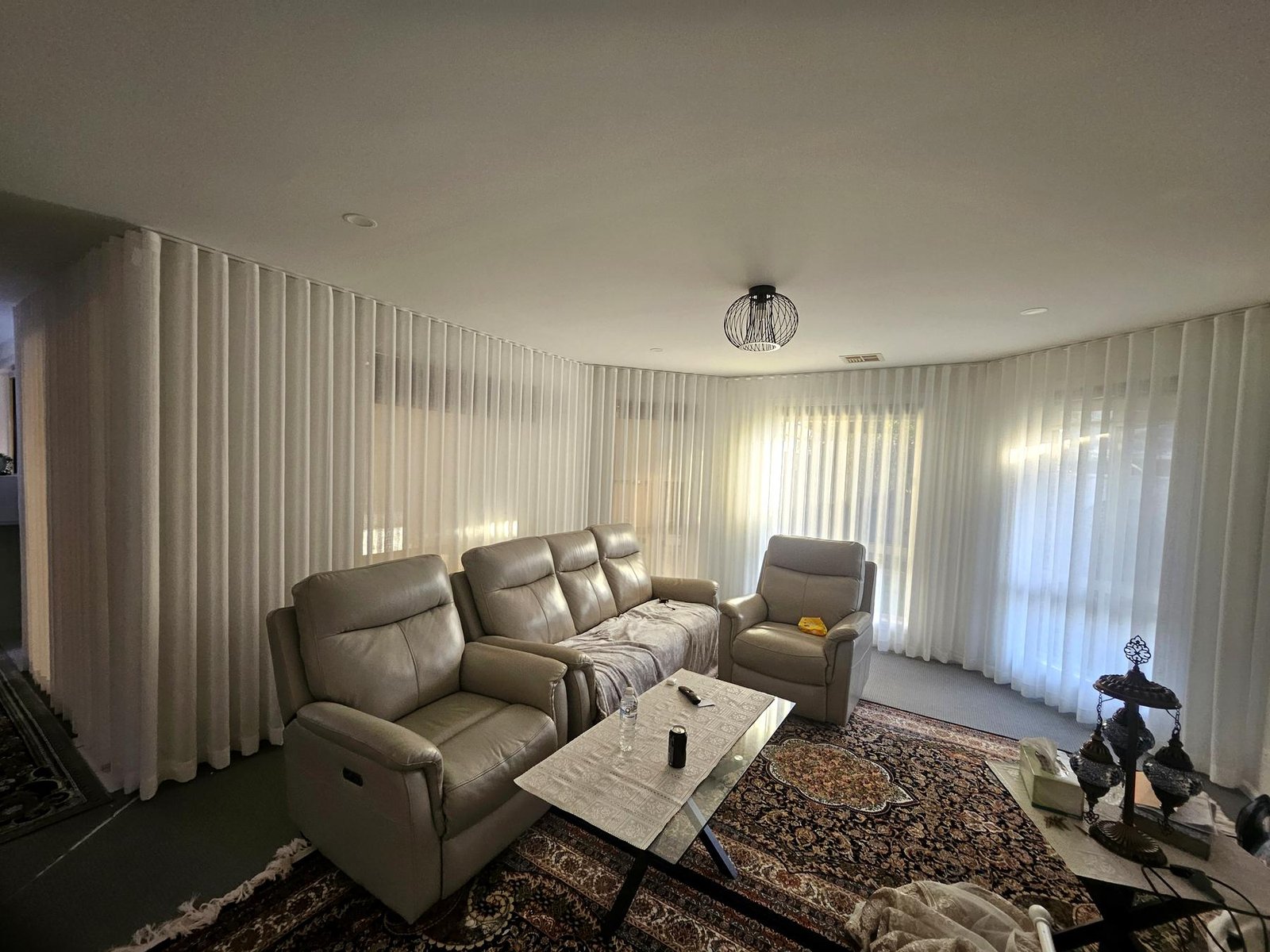 White sheer wave-fold curtains around a lounge room