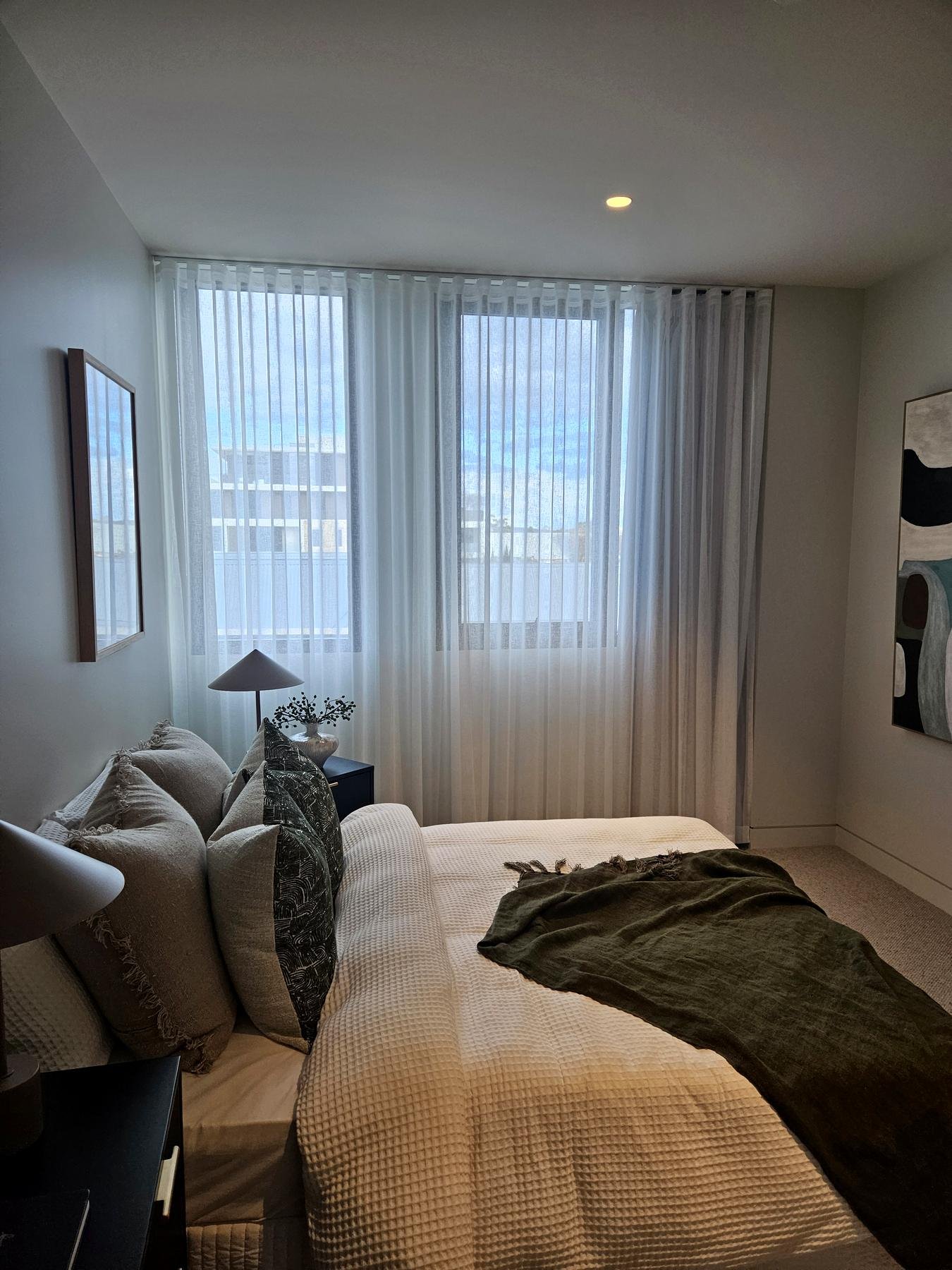 White sheer curtains in a bright display-home bedroom