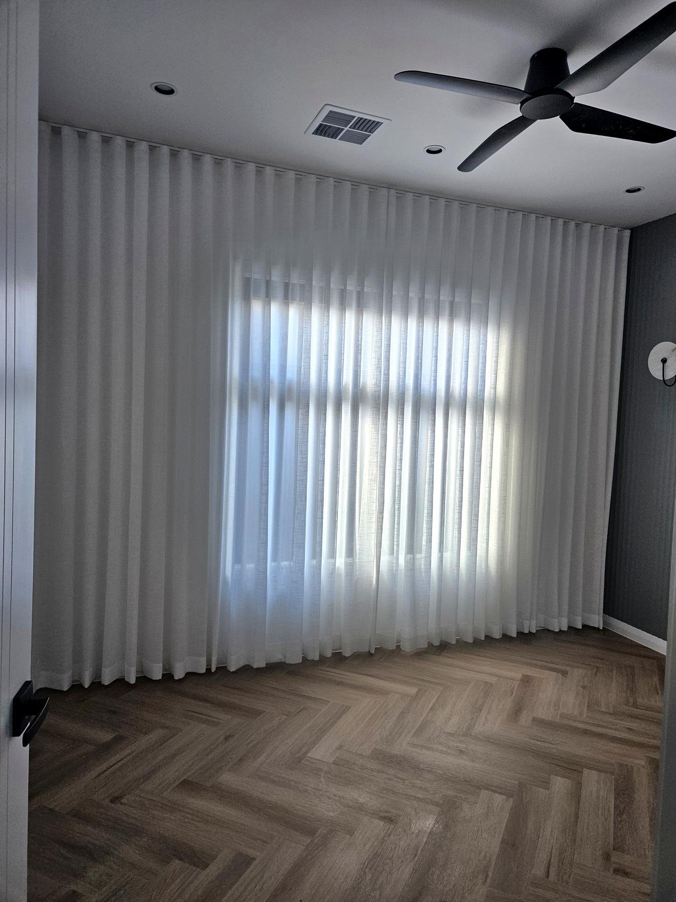 Sheer curtains on a ceiling track in a modern living room