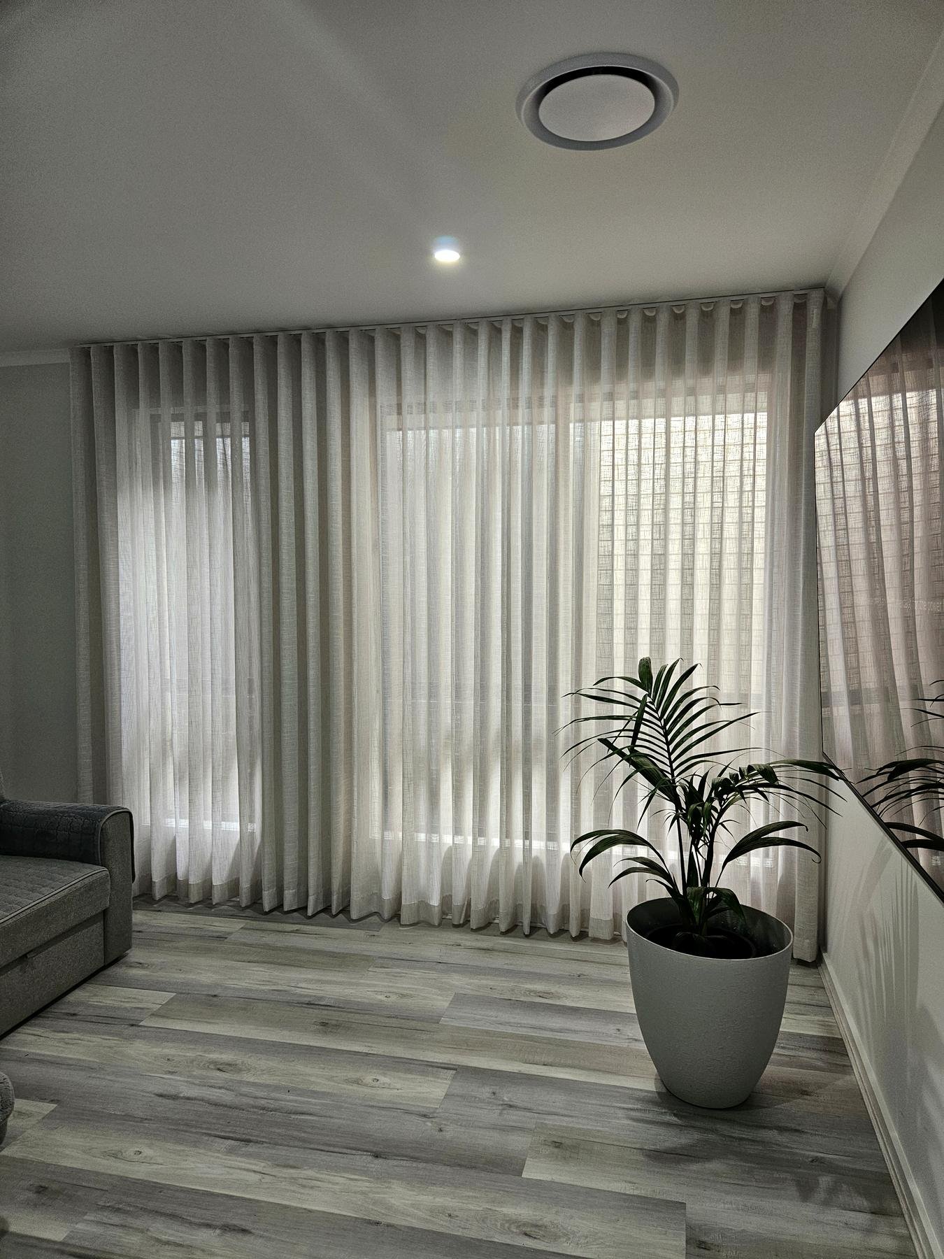 Sheer curtains in a living room with a grey sofa