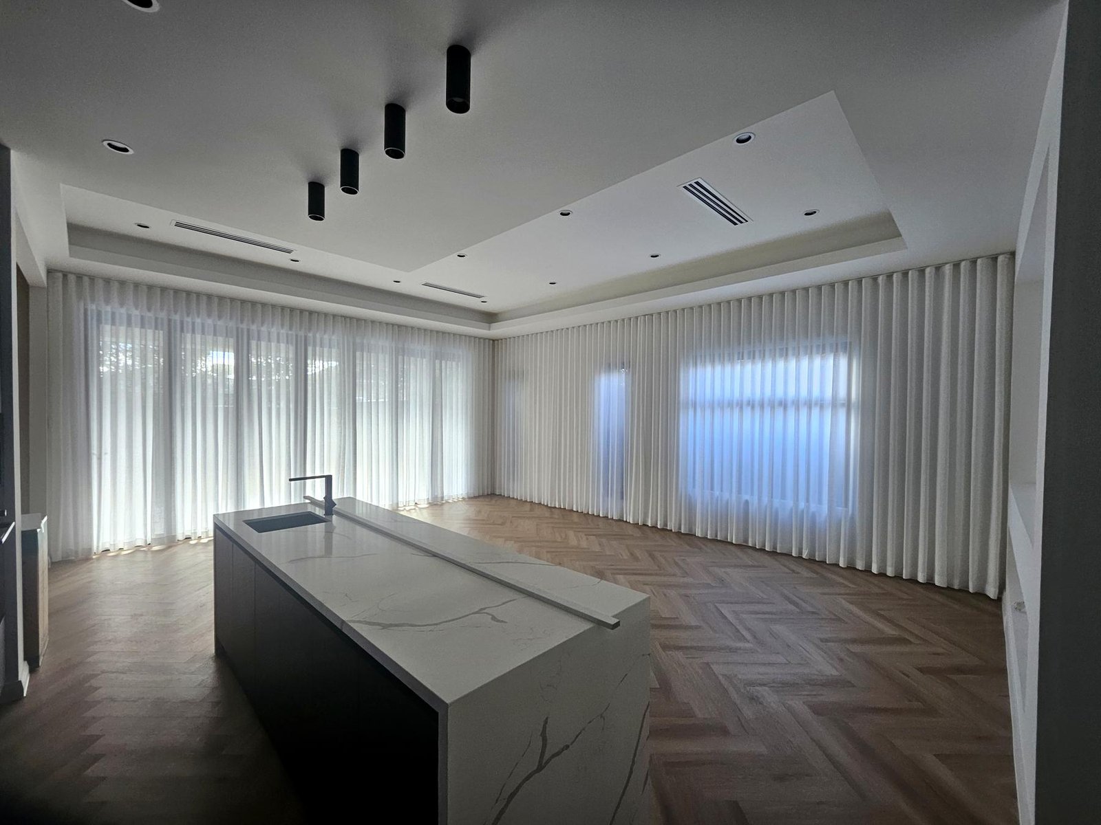 Wall-to-wall sheer curtains in an open-plan kitchen