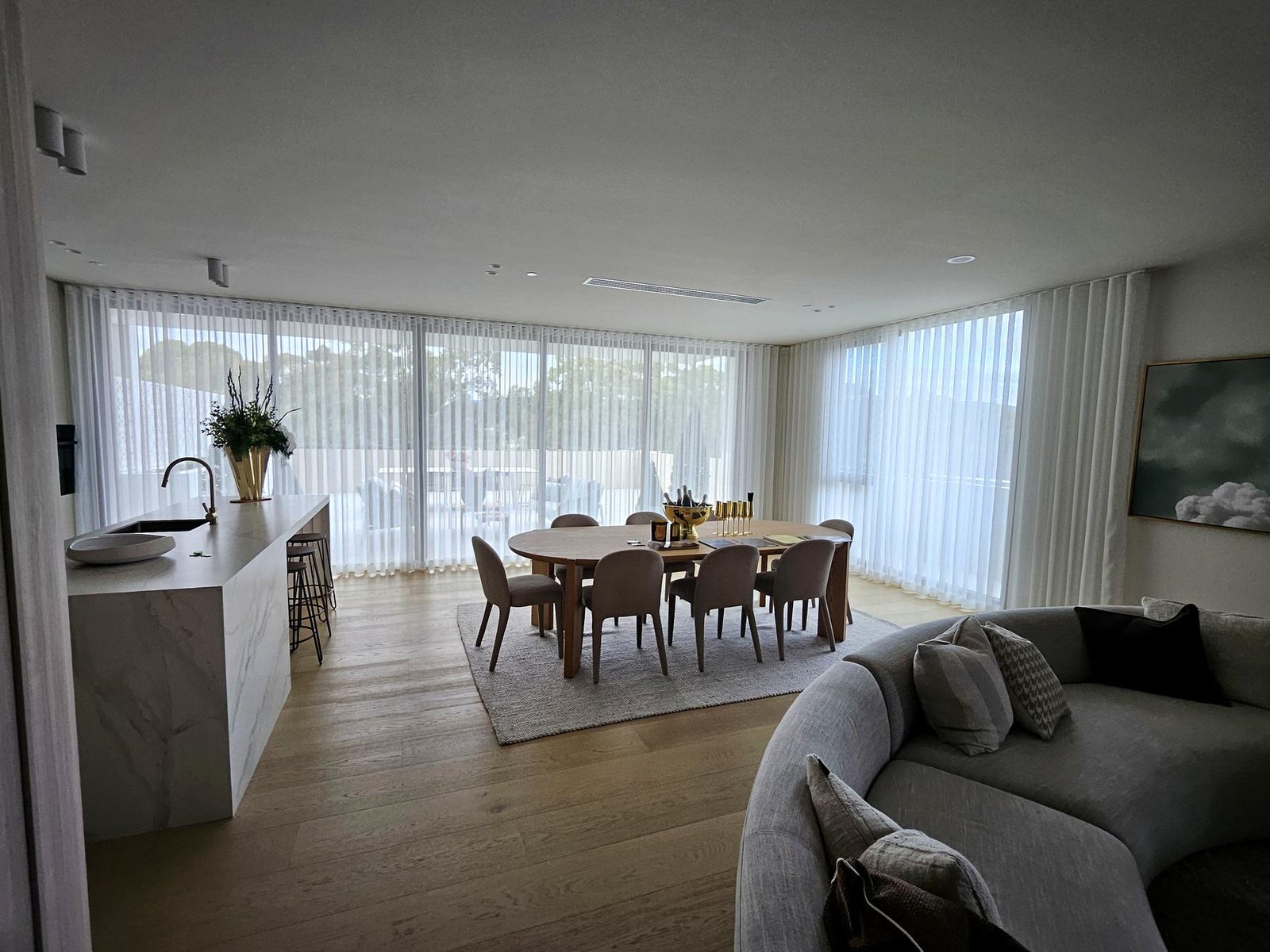 Sheer curtains across an open-plan kitchen and dining room